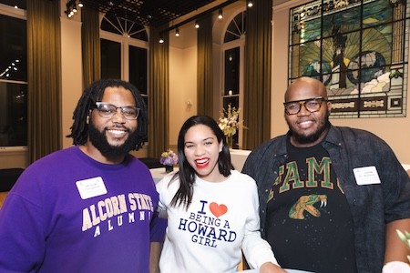 Attendees wearing HBCU sweaters and smiling at HB/CU Connections reception
