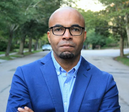 Photo of Mario Small wearing black glasses, a blue blazer, and a blue collared shirt 