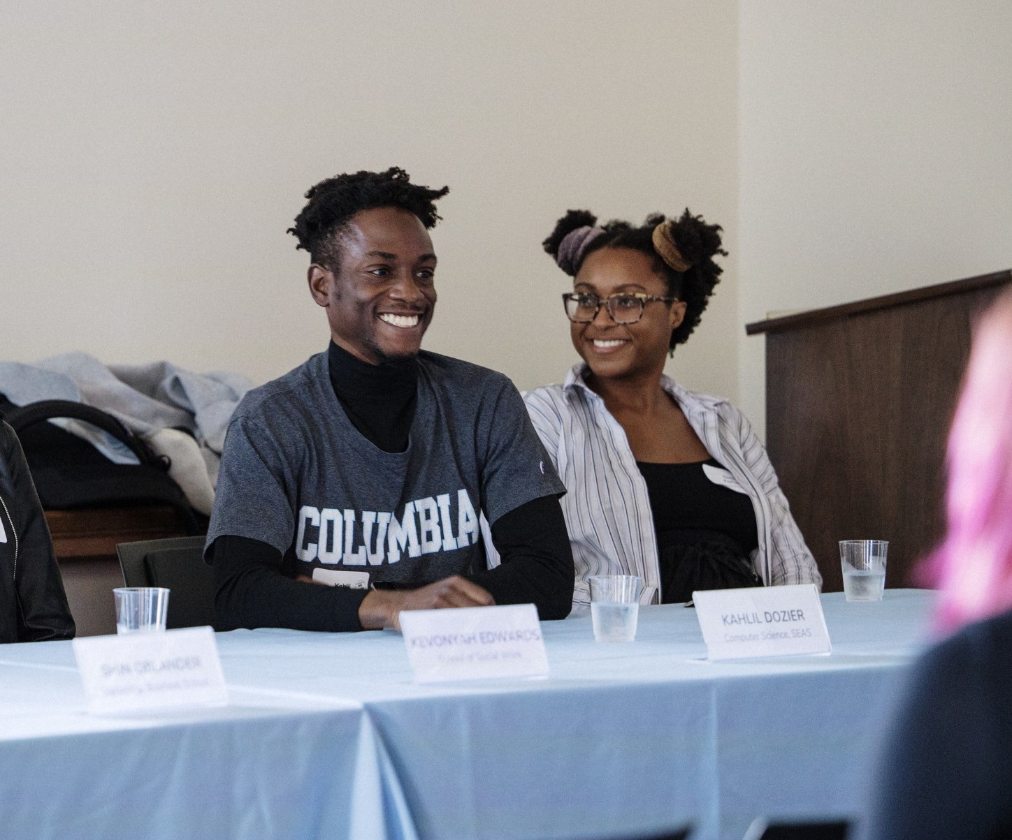Student panelists sitting at a table smilling