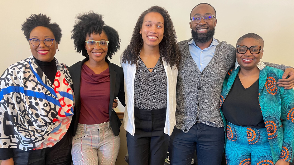 Photo of the moderator and four panelists smiling at the camera: Courtney Cogburn, Natasha Johnson, Melissa Thompson, Charles Lea, and Nkemka Anyiwo