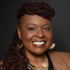 Head shot of Ovita Williams with long hair and circular earrings and necklace