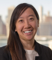 Headshot of Vina Tran, with long dark hair, white shirt, and black jacket