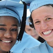 Two smiling graduates looking at the camera