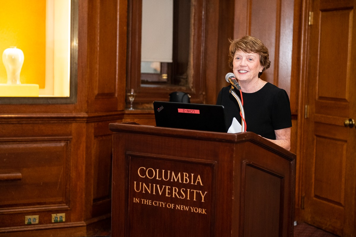 Woman speaking at podium with inscription "Columbia University in the City of New York" 