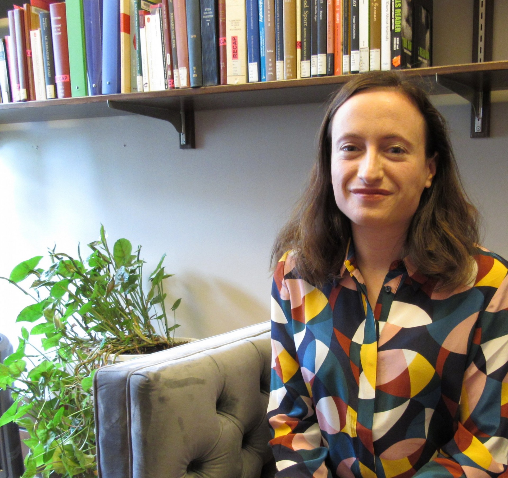 Eliza Zingesser sits in front of bookcase.