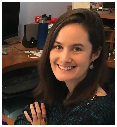 Melanie Brucks headshot sitting at her desk