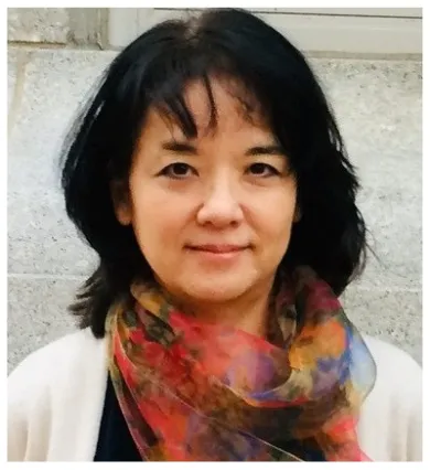 Head shot of Ellie Hisama wearing a multicolored red orange scarf and white sweater