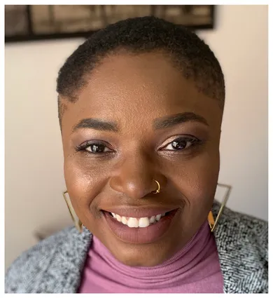 head shot of Nkemka Anyiwo wearing a pink shirt and gray blazer