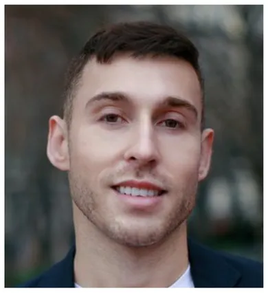 Head shot of Jon Freeman standing in front of a blurry gray background