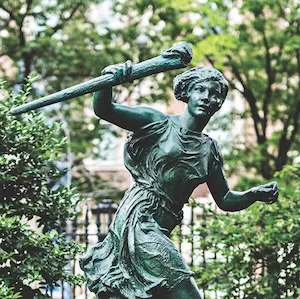 A bronze statue of a girl running with a torch.