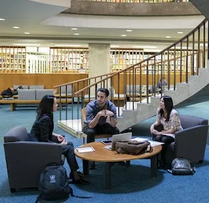 Students converse around a table at the School of International and Public Affairs